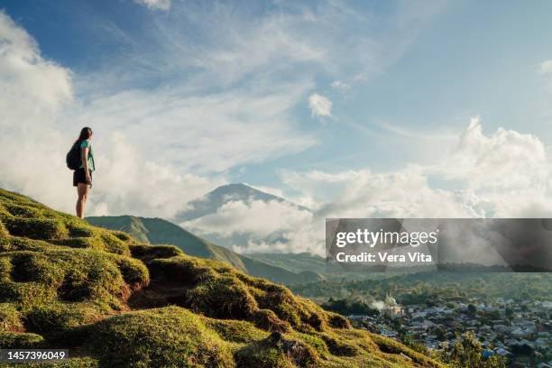 panoramic view of unrecognizable hispanic woman standing on peak mountain in lombok island - bali volcano stock pictures, royalty-free photos & images