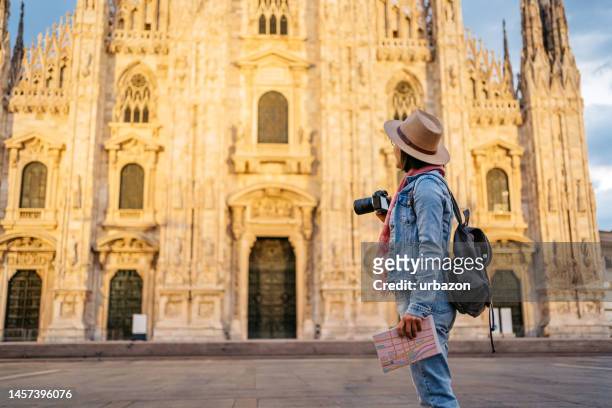joven turista tomando una foto de la catedral de milán - photographing fotografías e imágenes de stock