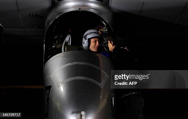 Pilot Bertrand Piccard speaks to his wife Michele before take off on the Swiss sun-powered aircraft Solar Impulse on June 5, 2012 at the Barajas...