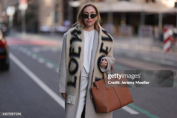 Sonia Lyson seen wearing Tods beige Iconic Di big bag, fluffy beige boots, shades, a Loewe fluffy beige logo scarf, H&M grey matching jogger, a The...