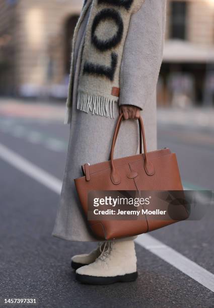 Sonia Lyson seen wearing Tods beige Iconic Di big bag, fluffy beige boots, shades, a Loewe fluffy beige logo scarf, H&M grey matching jogger, a The...