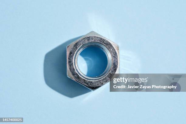 hex nut on blue background - wrench stock pictures, royalty-free photos & images
