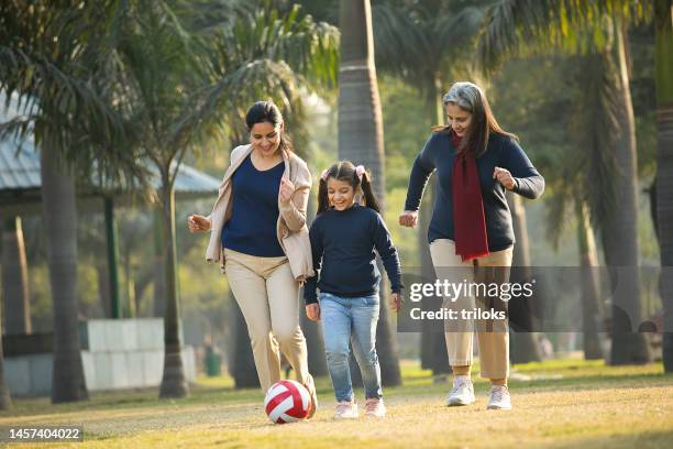 happy indian family playing with sports ball at park - senior kicking stock pictures, royalty-free photos & images