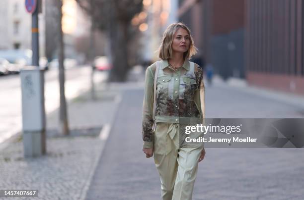 Olga Löffler seen wearing a total Marc Cain look with a green printed blouse and matching pants, a pink long coat, heels and a leather bag during the...