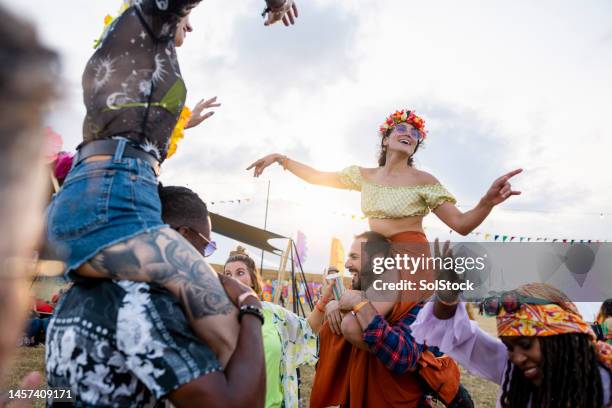 sharing a shoulder carry at the festival - music festival uk stock pictures, royalty-free photos & images