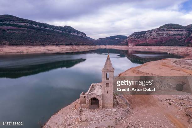 aerial view of the ghost village emerging from the sau reservoir after critical drought in spain. - reservoir stock-fotos und bilder