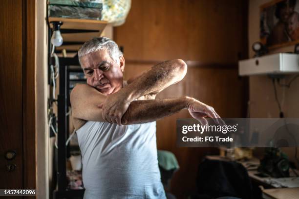 senior man stretching arms at home - 肘 個照片及圖片檔