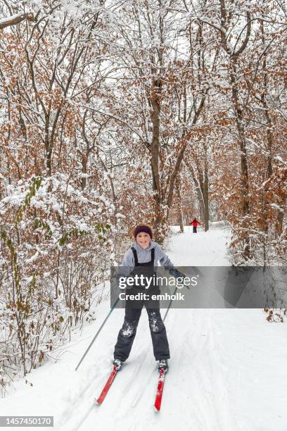 girl cross country skiing down hill on winter day - minnesota forest stock pictures, royalty-free photos & images