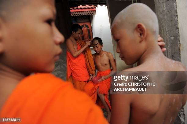 Thailand-religion-society-gender" by Janesara FUGAL This picture taken on June 15, 2011 shows Buddhist novice monk and aspiring ladyboy Pipop...