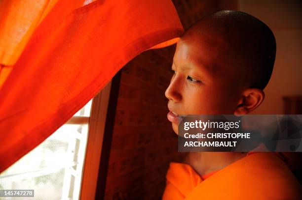 Thailand-religion-society-gender" by Janesara FUGAL This picture taken on June 16, 2011 shows Buddhist novice monk and aspiring ladyboy Pipop...