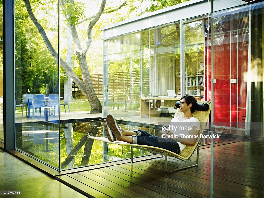 Man sitting in chair looking across courtyard