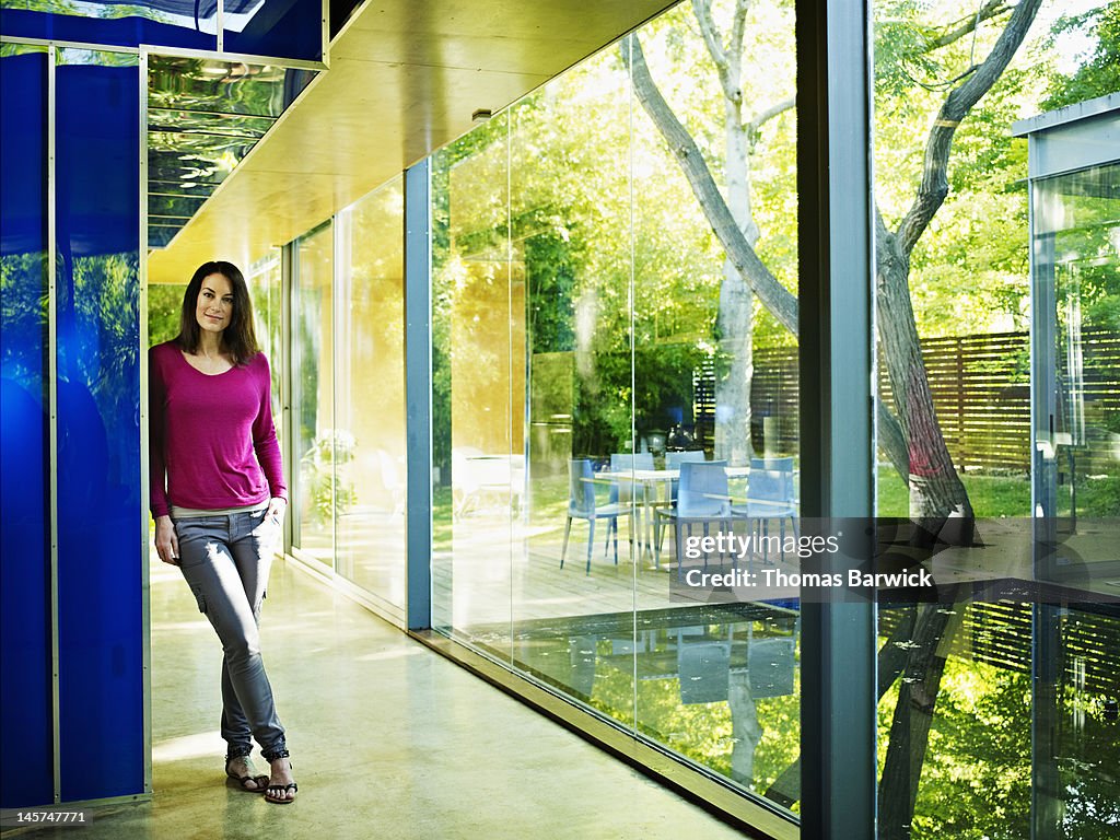 Woman standing in hallway of glass walled home