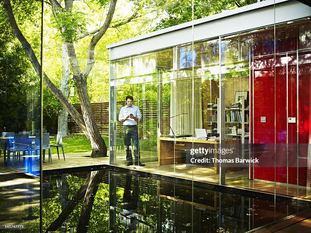 Architect in home office looking at smart phone