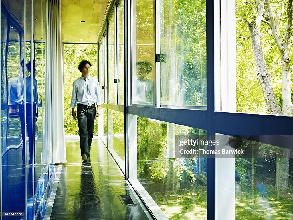 Man walking down hallway of home