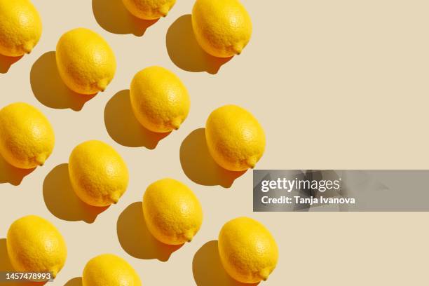 pattern of citrus-fruit of lemons on beige background. healthy food, diet and detox concept. flat lay, top view, copy space - lemon stockfoto's en -beelden