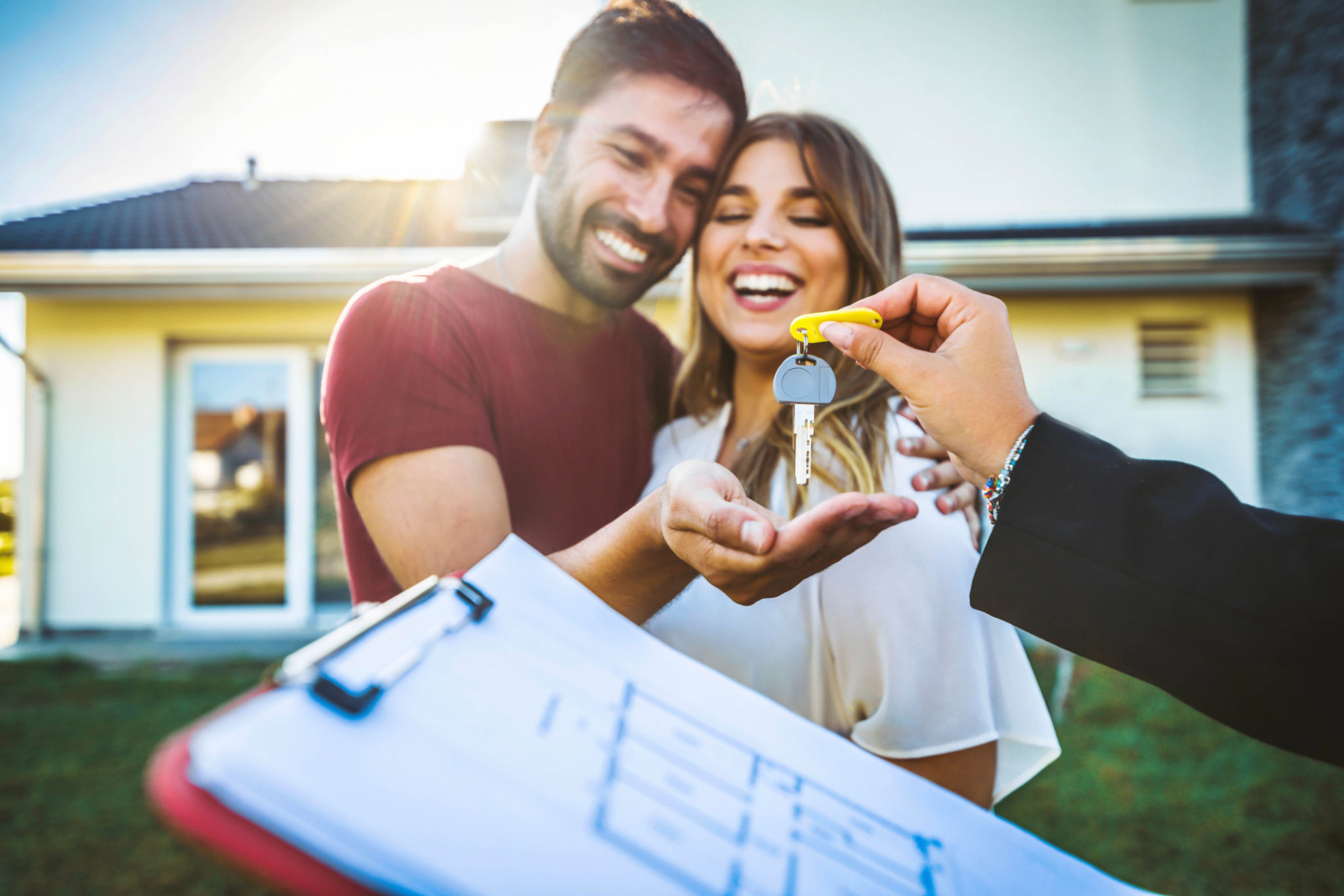 Happy millennial couple receiving keys from real estate agent, purchasing real estate - Family meeting with real estate agent - New house and real estate concept Happy millennial couple receiving keys from real estate agent, purchasing real estate - Family meeting with real estate agent - New house and real estate concept