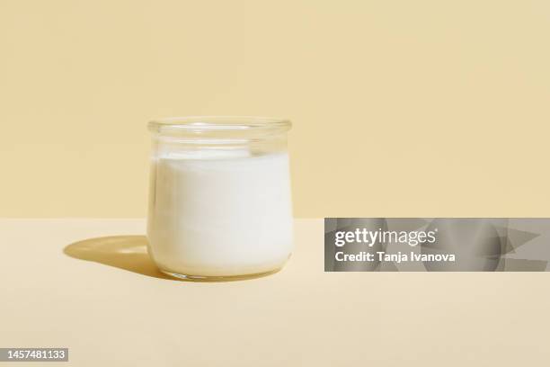 glass of organic fresh milk on beige background. dairy, grow and drink concept. minimal style, copy space. - yogurt foto e immagini stock