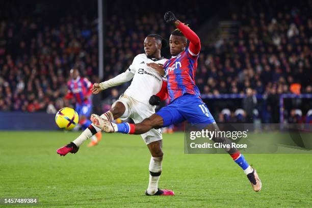 Aaron Wan-Bissaka of Manchester United is challenged by Wilfried Zaha of Crystal Palace during the Premier League match between Crystal Palace and...