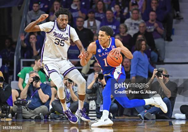 Kevin McCullar Jr. #15 of the Kansas Jayhawks drives with the ball against Nae'Qwan Tomlin of the Kansas State Wildcats in overtime at Bramlage...