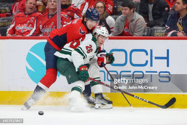 Dylan Strome of the Washington Capitals and Connor Dewar of the Minnesota Wild battle for a puck during a game at Capital One Arena on January 17,...