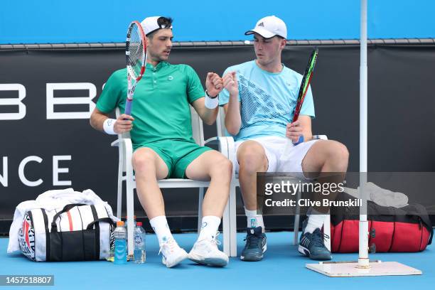 Julian Cash of Great Britain and Henry Patten of Great Britain bump fists in their round one doubles match against Pedro Cauchin of Argentina and...