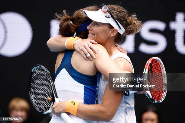 Samantha Stosur of Australia embraces Alize Cornet of France after their round one doubles match against Hao-Ching Chan of Chinese Taipei and...