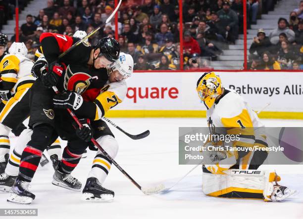 Brady Tkachuk of the Ottawa Senators is held by Evgeni Malkin of the Pittsburgh Penguins resulting in a holding penalty as his teammate Casey DeSmith...