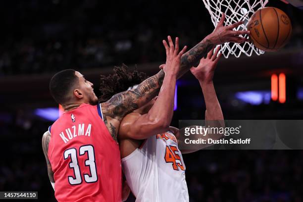 Kyle Kuzma of the Washington Wizards and Jericho Sims of the New York Knicks go for a rebound during the third quarter of the game at Madison Square...