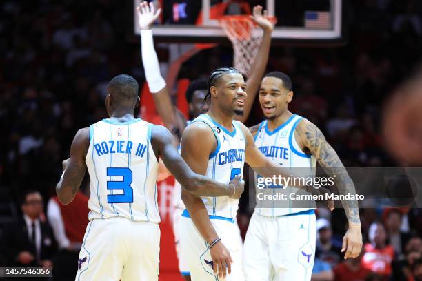 Dennis Smith Jr. #8 of the Charlotte Hornets reacts with teammates Terry Rozier and P.J. Washington during the second half against the Houston...