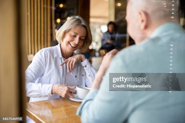 senior couple drinking coffee on a date at a cafe - coffee shop couple stock pictures, royalty-free photos & images