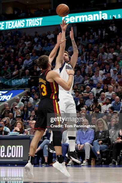 Luka Doncic of the Dallas Mavericks shoots the ball against Bogdan Bogdanovic of the Atlanta Hawks in the fourth quarter at American Airlines Center...