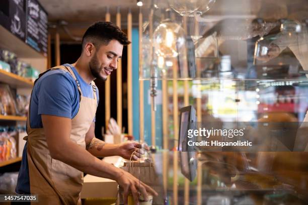 waiter working at a cafe preparing a delivery order - bakery apron bildbanksfoton och bilder