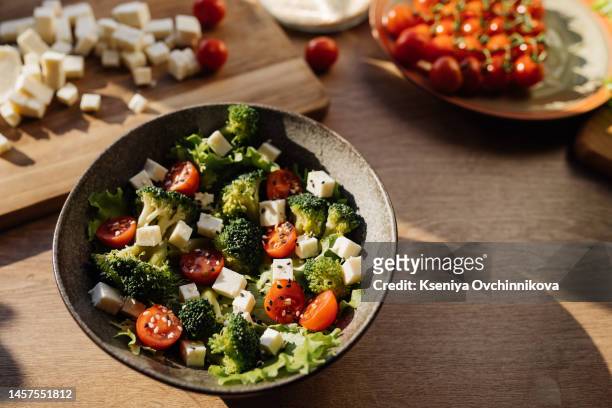 healthy broccoli salad with feta cheese sun dried tomatoes pine nuts.. vegetarian low carb keto diet - cheese salad stock-fotos und bilder