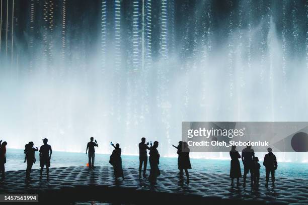 unrecognisable people looking the fountain performance - dubai tourism stock pictures, royalty-free photos & images