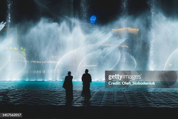 des personnes méconnaissables qui regardent la performance de la fontaine - las vegas skyline night photos et images de collection