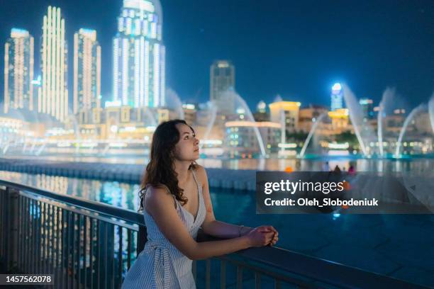 woman  looking at the dubai fountain at night - dubai tourist stock pictures, royalty-free photos & images