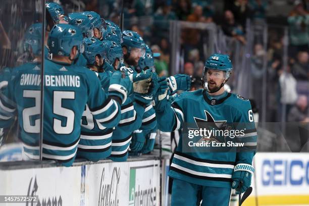 Erik Karlsson of the San Jose Sharks is congratulated by teammates after he scored a goal against the Dallas Stars in the third period at SAP Center...