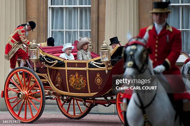 Footmen begin to dismount as Britain's Queen Elizabeth II, Camilla, Duchess of Cornwall, and Prince Charles, Prince of Wales, arrive at Buckingham...