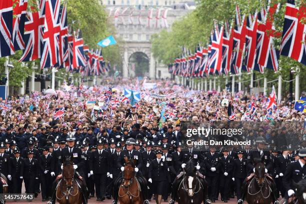 The crowd is escorted down The Mall during the Diamond Jubilee carriage procession after the service of thanksgiving at St.Paul’s Cathedral on the...