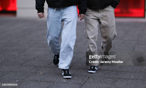 Alex Bönisch and Tobi Bönisch seen wearing black bomber jacket, blue wide jeans trousers, beige wide trousers and Adidas gazelle sneaker, before the...
