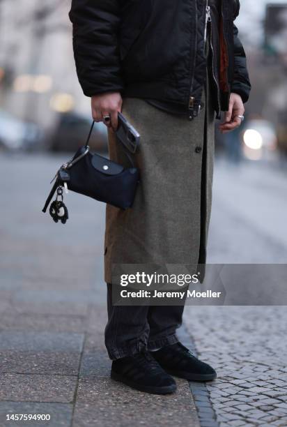 Noah Kächelin seen wearing Adidas gazelle sneaker, black bomber jacket, green long coat, black trousers and a small black bag before the William Fan...