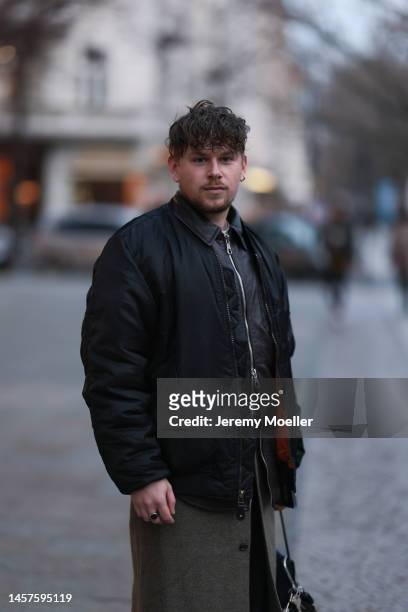 Noah Kächelin seen wearing black leather jacket, black bomber jacket, green long coat, black trousers and a small black bag before the William Fan...