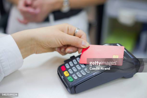 everyday shopping in clothing store - customers pay with contactless cards imagens e fotografias de stock