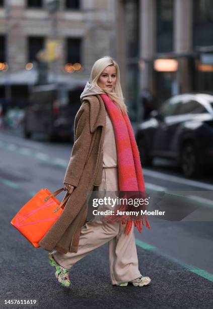 Palina Kozyrava seen wearing Maison Margiela beige long coat, Louis Vuitton colorful orange big bag, Reebok colorful painted sneaker, H&M beige...