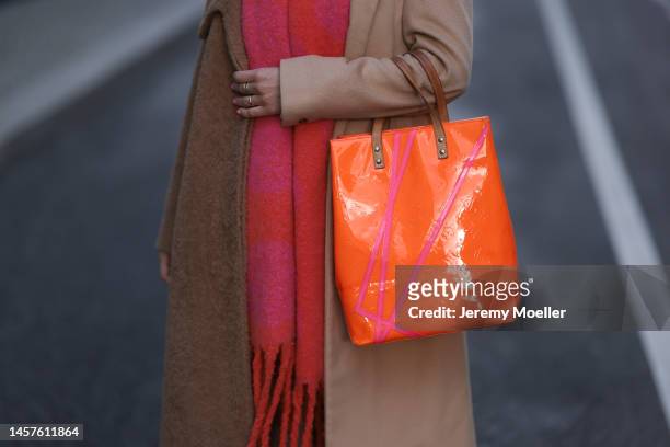 Palina Kozyrava seen wearing Maison Margiela beige long coat, Louis Vuitton colorful orange big bag, Reebok colorful painted sneaker, H&M beige...