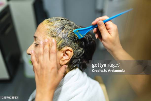 hairdresser dyes senior woman's hair at home - hair dye stock pictures, royalty-free photos & images