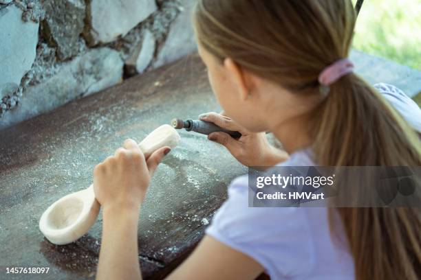 school project - girl carving her own wooden spoon using electric milling machine for wood craft - wooden spoon stock pictures, royalty-free photos & images