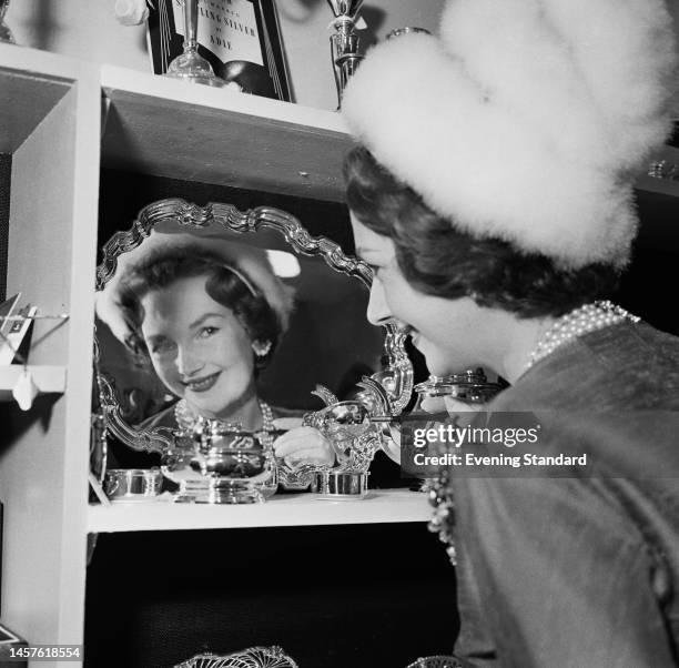 Raine Legge, Lady Lewisham , looking at a silver platter on display at a watch and jewellery trade fair on September 15th, 1960.