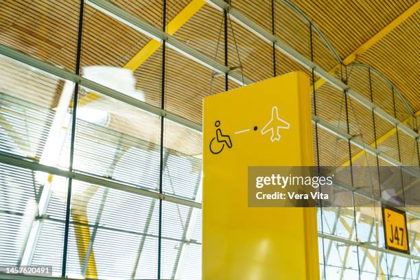 yellow international symbol of people with disabilities at airport boarding gate - airline ticket icon stock pictures, royalty-free photos & images