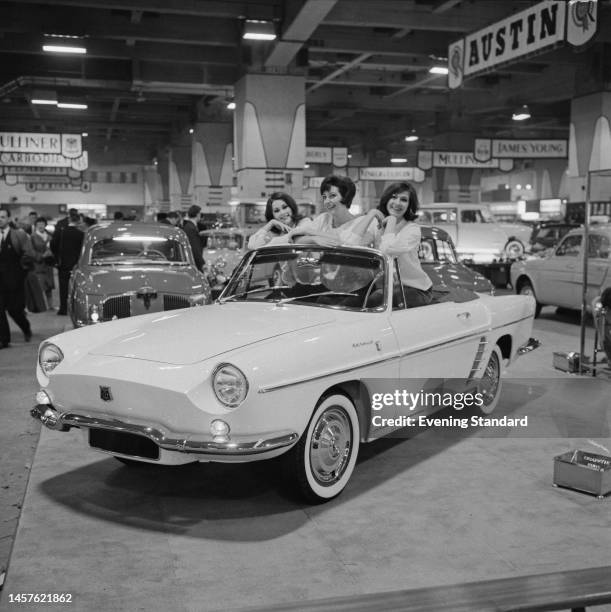 Three women posing in an open-top convertible Renault Caravelle at the British International Motor Show at Earls Court in London on October 18th,...